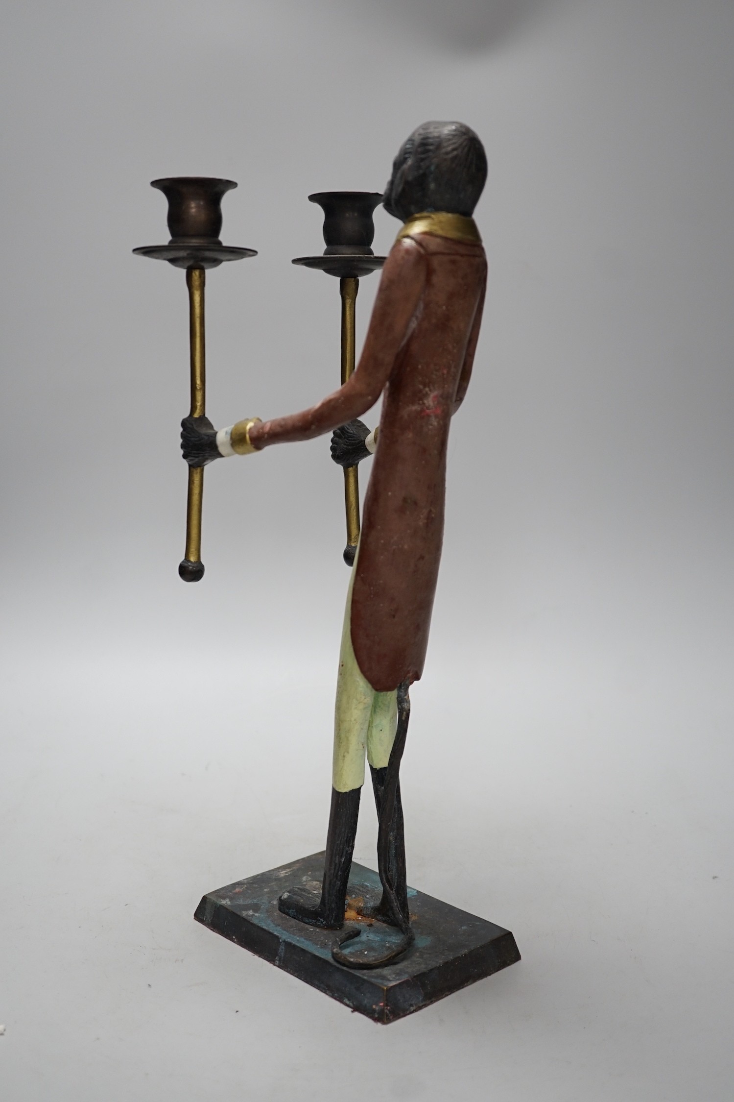 A painted iron novelty two branch monkey candlestick, 44cms high